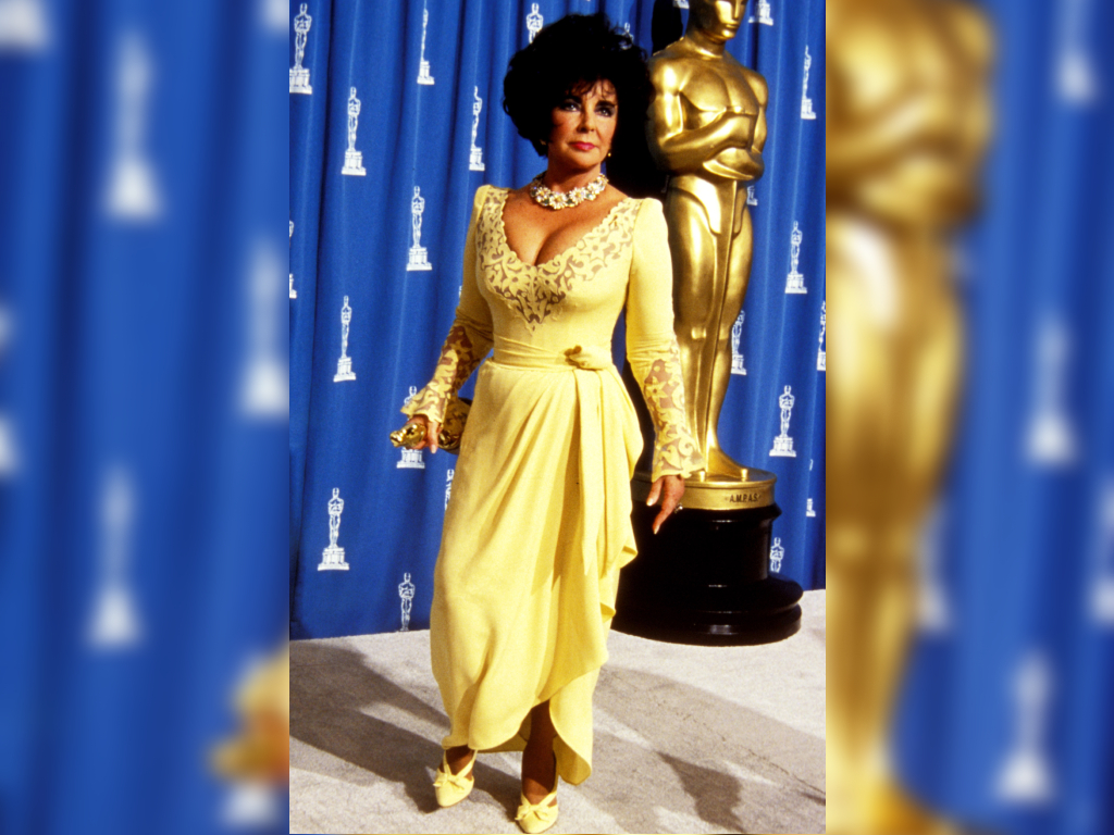 Elizabeth Taylor wears a yellow gown to the 1993 Academy Awards.