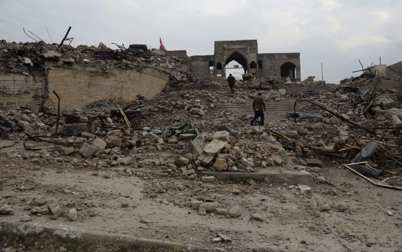 People inspect the destroyed Mosque of the Prophet Younis, or Jonah, in Mosul, Iraq, Saturday, Jan. 21, 2017.