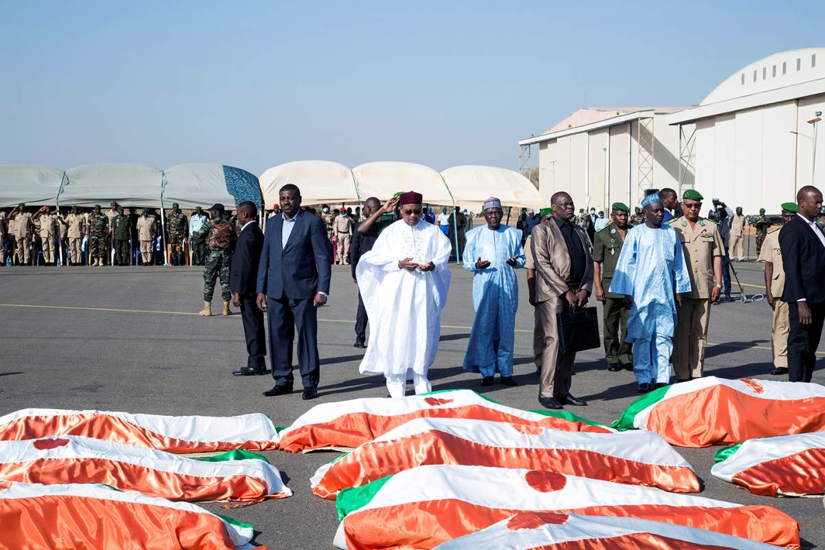 Flag-draped soldiers, killed during an attack on the army camp on the Niger- Mali border, are displayed during their burial ceremony at military airport in Niamey, Niger, December 13, 2019.