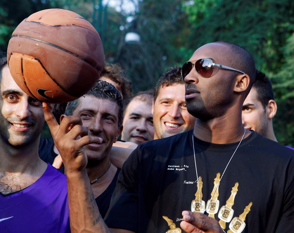 FILE - In this Sept. 28, 2011, file photo, U.S. basketball star Kobe Bryant plays with a ball during a sponsor's appearance in Milan, Italy. In Europe where Bryant grew up, the retired NBA star is being remembered for his "Italian qualities." Italian basketball federation president Giovanni Petrucci tells The Associated Press that Bryant is "particularly important to us because he knew Italy so well, having lived in several cities here. He had a lot of Italian qualities." (AP Photo/Luca Bruno, File).