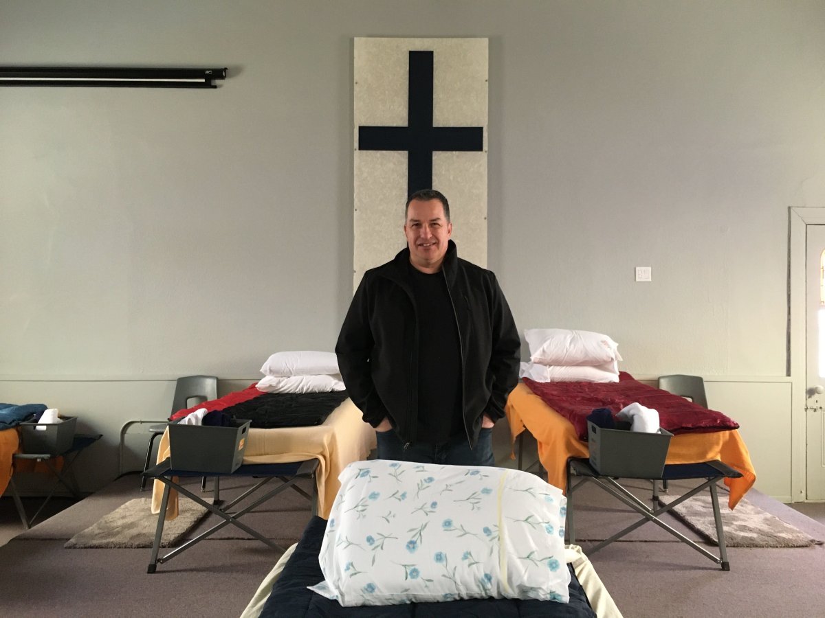 Pastor Dan Morand stands inside Beth Emmanuel Church, where beds have been set up for the homeless.