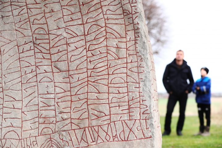A father and a son look at the Viking-era Rök runestone near the Lake Vattern and the town of Odeshog, in Ostergotland, Sweden, on Jan. 9, 2020. 