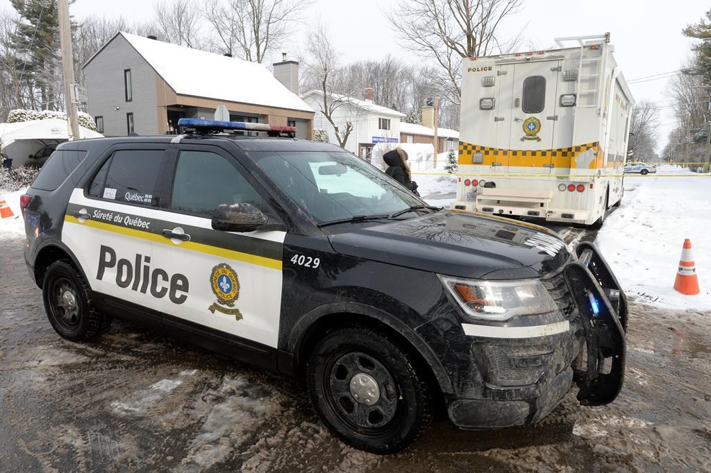 Police vehicles cordon off an area outside a home in Mascouche, Que., Thursday, Jan.16, 2020. Quebec provincial police are investigating the killing of a woman in her 30s inside a home in Mascouche. THE CANADIAN PRESS/Ryan Remiorz