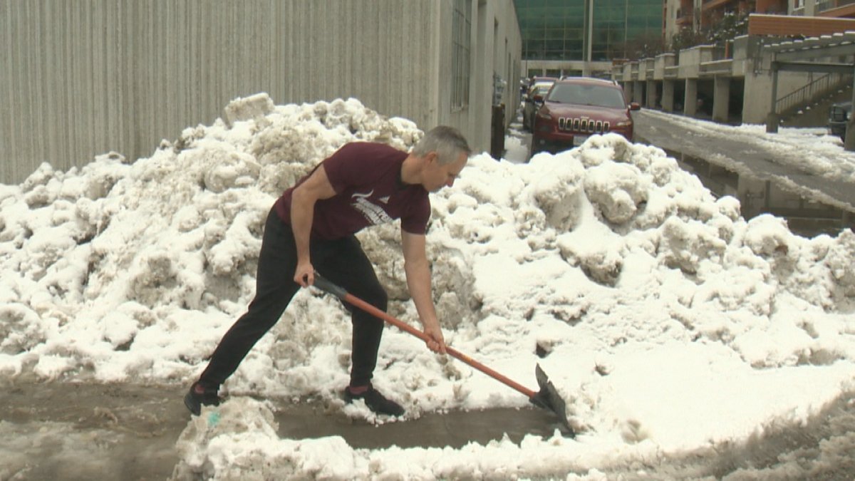 FILE. Chris Collins demonstrates proper form when shoveling snow.