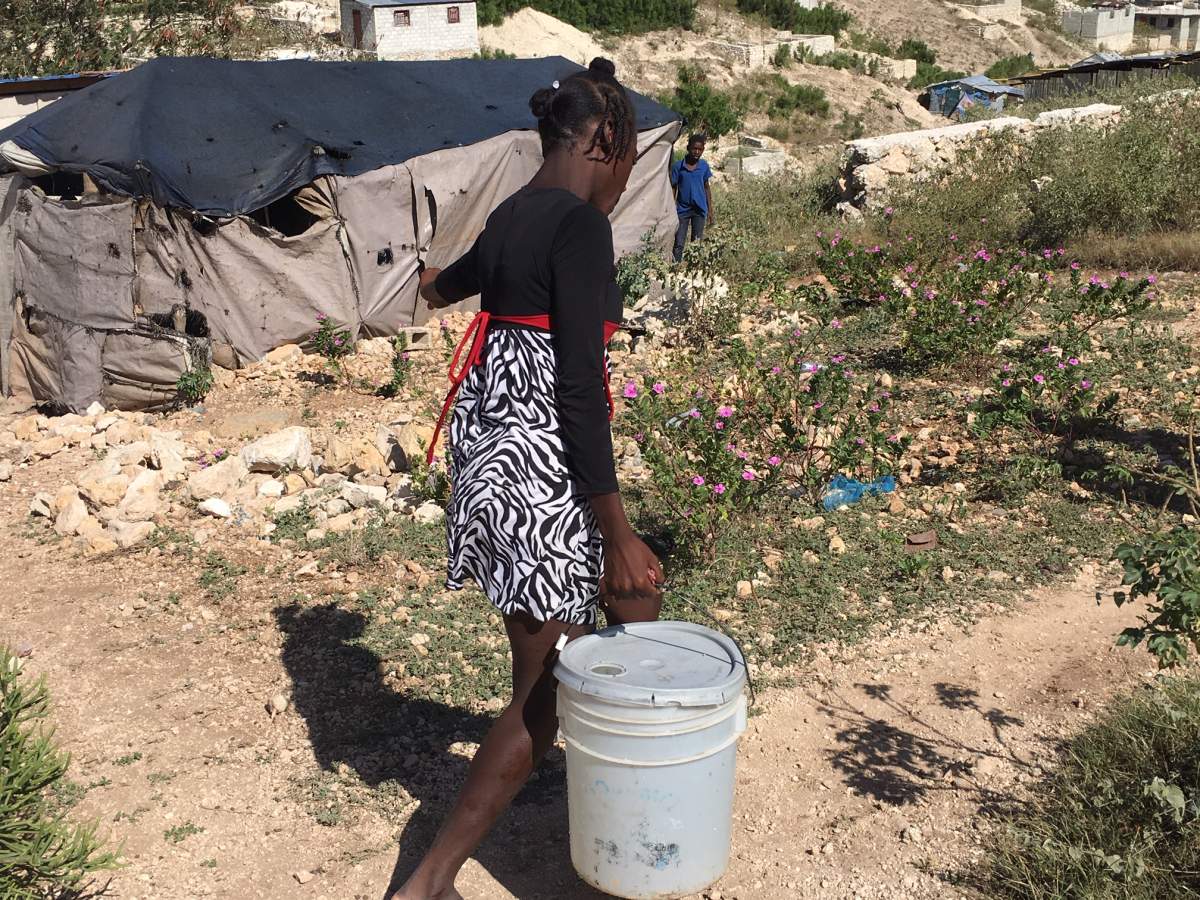 Magdala carries water back to her home.