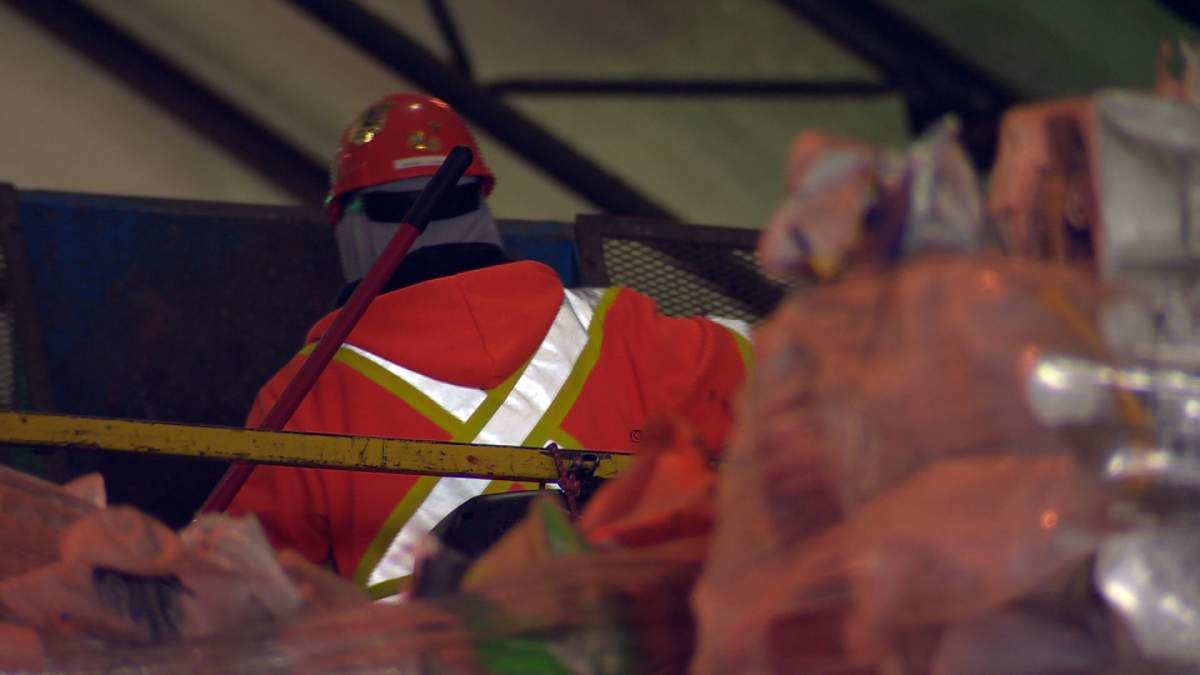An employee sorts through recycling.