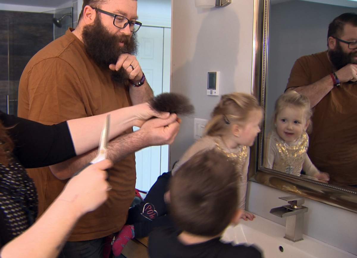 Lucas Menzie shaves his 13-inch beard.