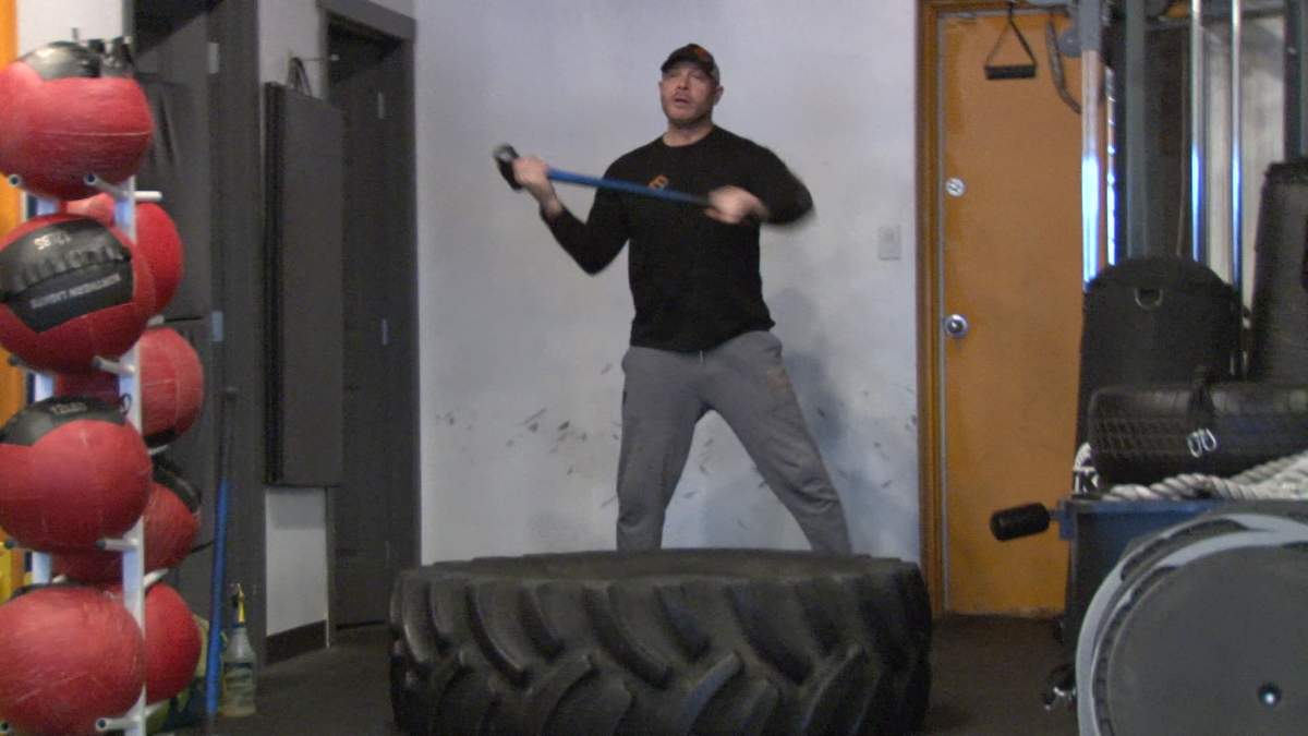 Mojo Fitness owner and personal trainer Ryan Grant demonstrates a sledge hammer swing, part of a HIIT circuit he does with his clients.
