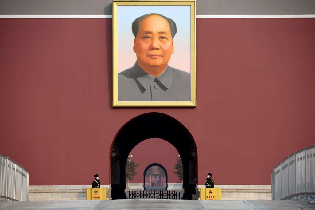 Chinese paramilitary police wear face masks as they stand guard beneath the large portrait of Chinese leader Mao Zedong at Tiananmen Gate adjacent to Tiananmen Square in Beijing, Monday, Jan. 27, 2020.