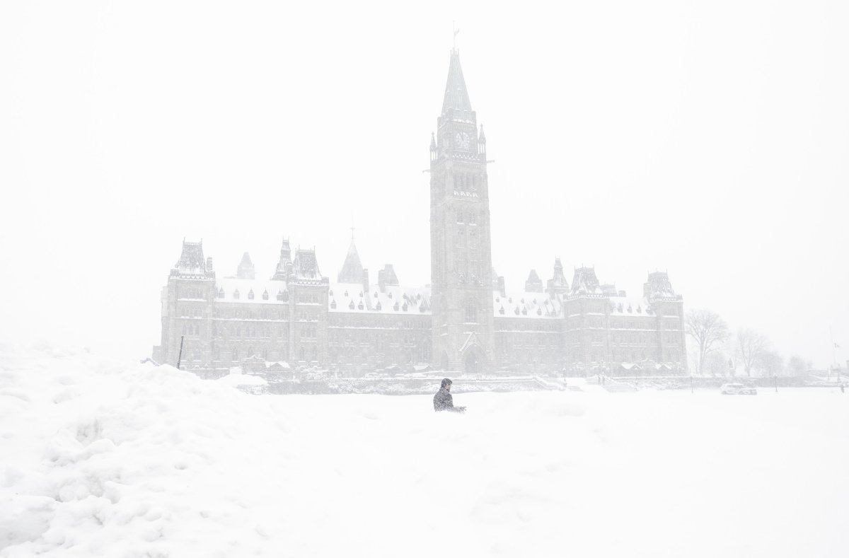 A pedestrian walks past a snowbank on Parliament Hill in Ottawa on Sunday, Jan. 20, 2019.
