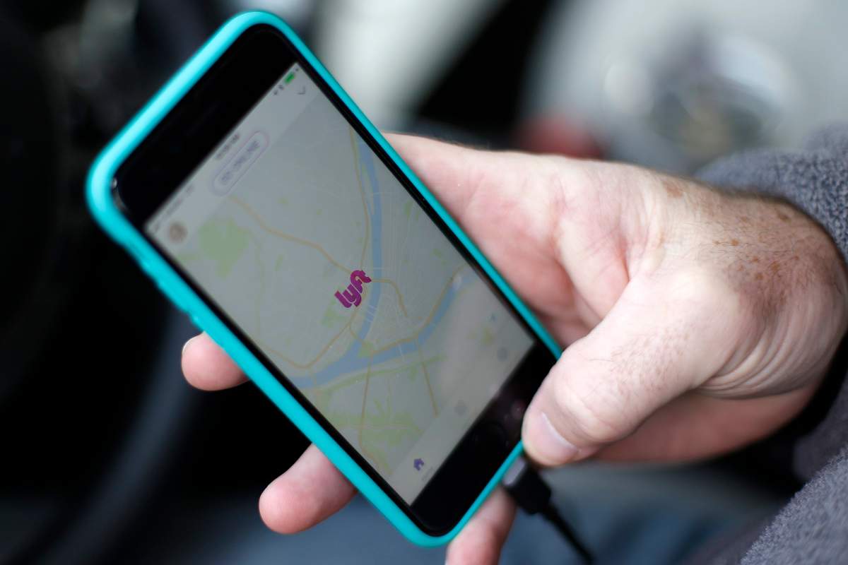In this Jan. 31, 2018, file photo, a Lyft driver opens the Lyft app on his phone while waiting for a fare in Pittsburgh.
