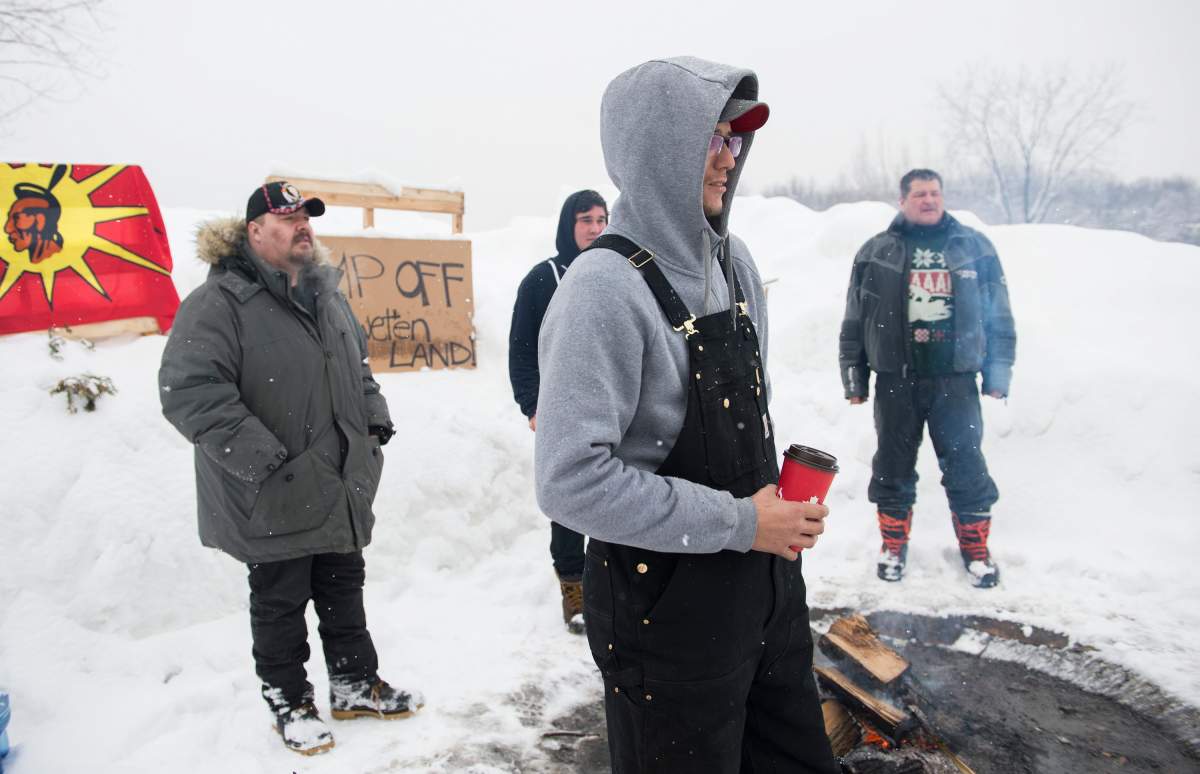 Members of the Mohawk community are shown on the Kahnawake reserve near a Canadian Pacific rail track south of Montreal, Monday, Feb. 10, 2020 to stand in solidarity with protesters opposed to a pipeline project in northwestern B.C.