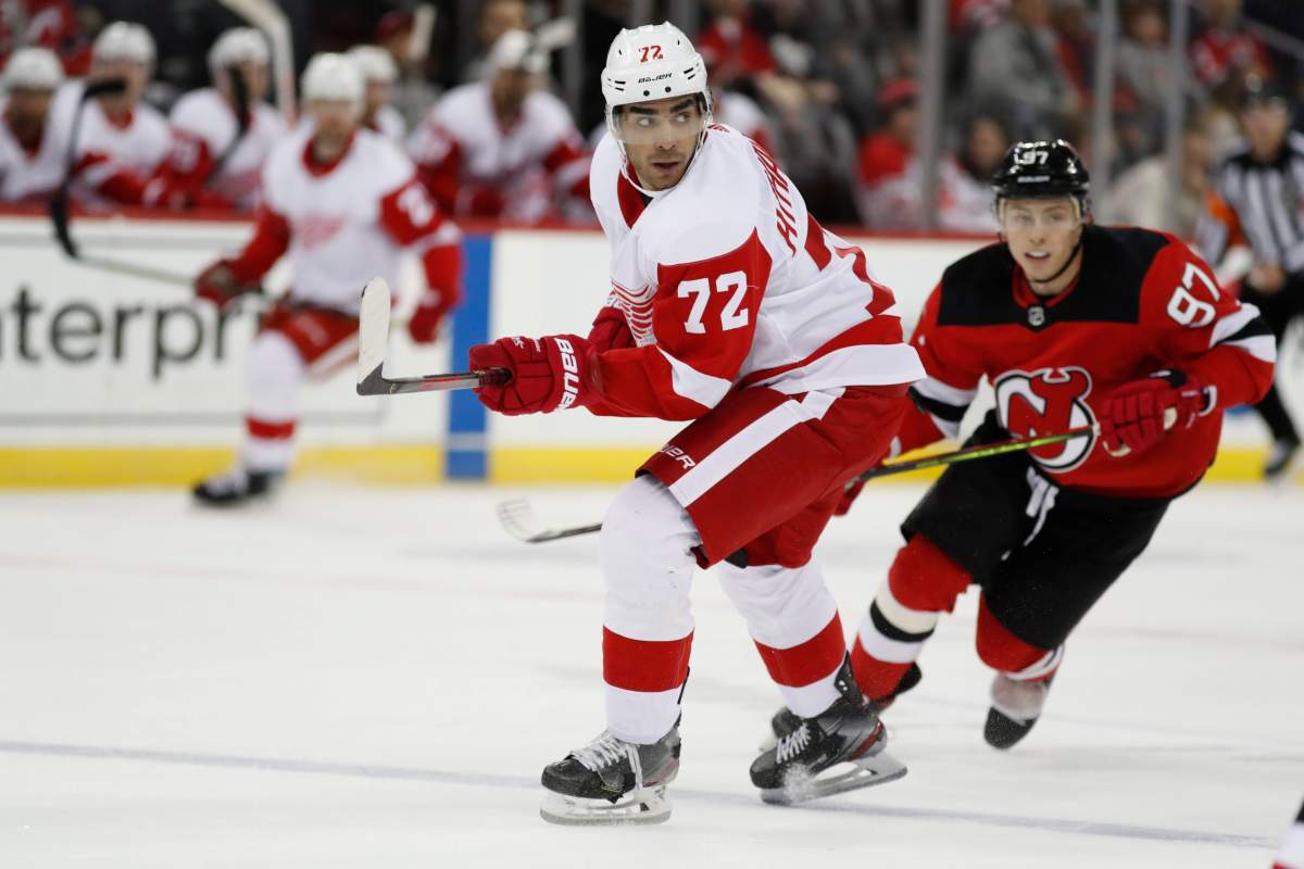 Detroit Red Wings left wing Andreas Athanasiou (72) passes with New Jersey Devils left wing Nikita Gusev (97) pursuing him during the first period of an NHL hockey game, Thursday, Feb. 13, 2020, in Newark, N.J.