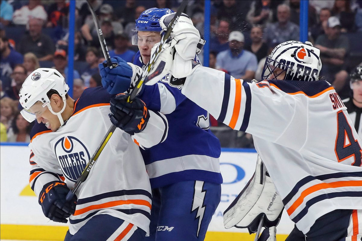 Edmonton Oilers goaltender Mike Smith reaches out to make a save as Caleb Jones defends against Tampa Bay Lightning's Yanni Gourde during the second period of an NHL hockey game Thursday, Feb. 13, 2020, in Tampa, Fla. (AP Photo/Mike Carlson).