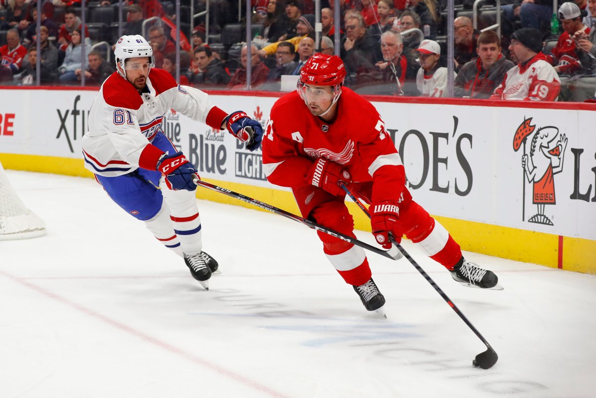 Detroit Red Wings center Dylan Larkin (71) protects the puck from Montreal Canadiens defenseman Xavier Ouellet (61) during the second period of an NHL hockey game Tuesday, Feb. 18, 2020, in Detroit.