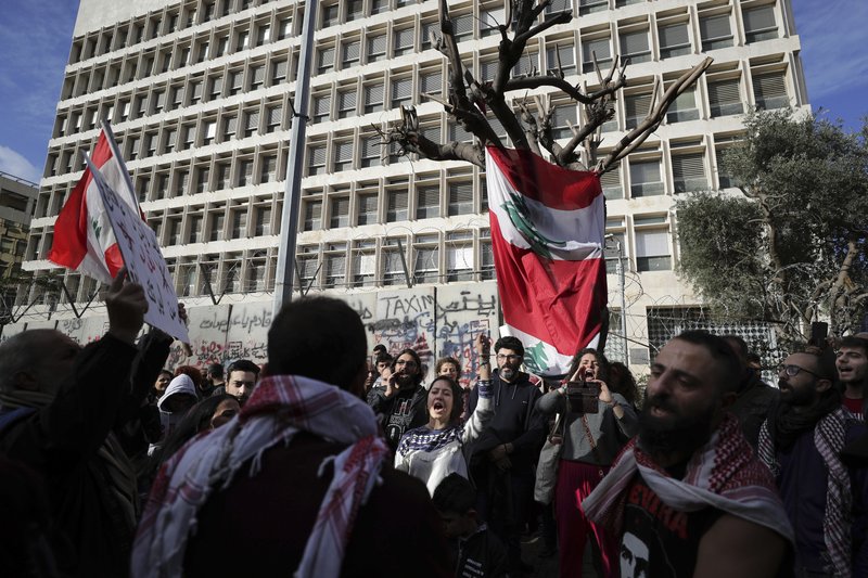 Anti-government protesters chant slogans, during ongoing protests against the Lebanese government in front of the Central Bank, in Beirut, Lebanon, Saturday, Feb. 1, 2020. 