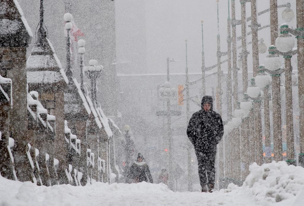 A man walks along the side walk near Parliament Hill during a snow storm in Ottawa, Thursday, Feb. 27, 2020.