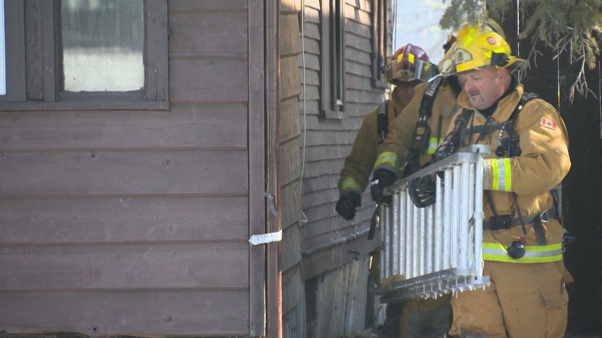 Regina firefighters use a ladder to reach the attic of a house that was on fire on Athol Street. The flames had reached to the attic of the home.