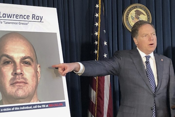 U.S. Attorney Geoffrey Berman points to a photo showing Lawrence Ray during a news conference, Tuesday, Feb. 11, 2020, in New York.