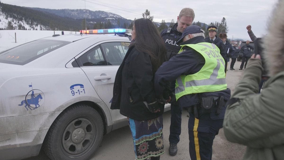 Police arrest one of the people blockading a CP Rail line near Chase, B.C. on Tuesday, Feb. 25, 2020. 