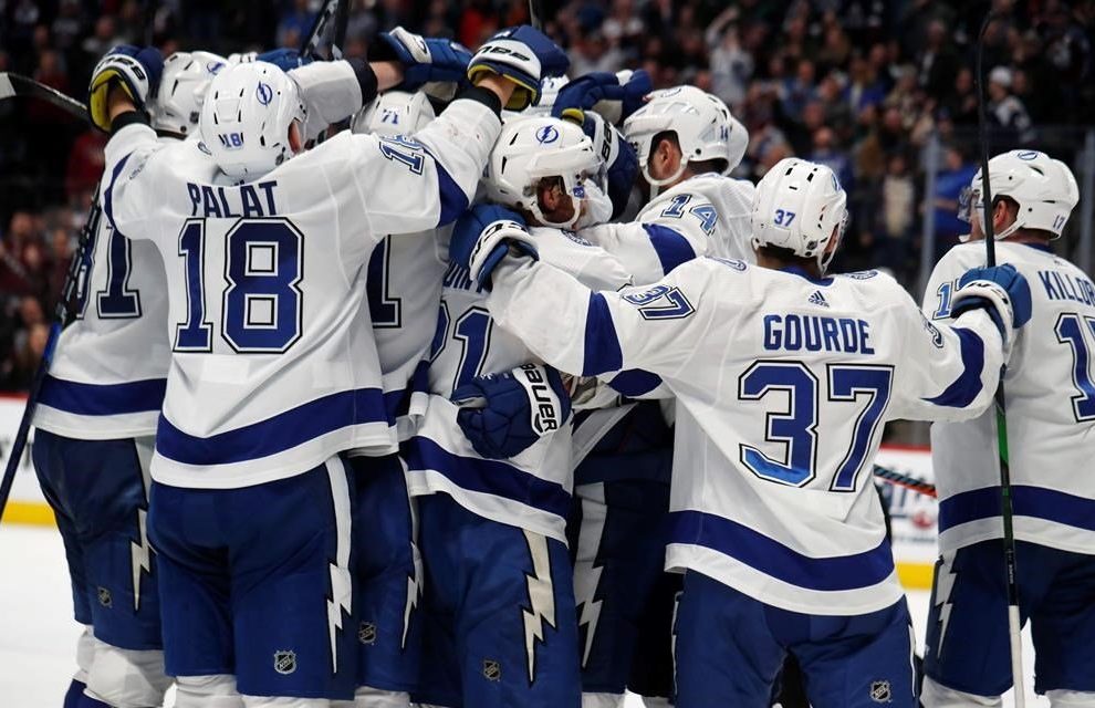 Tampa Bay Lightning right wing Nikita Kucherov is mobbed by teammates after scoring the winning goal in overtime of an NHL hockey game against the Colorado Avalanche Monday, Feb. 17, 2020, in Denver. The Lightning won 4-3.