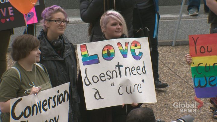 Someone holds a sign at an Edmonton rally in support of banning conversion therapy.
