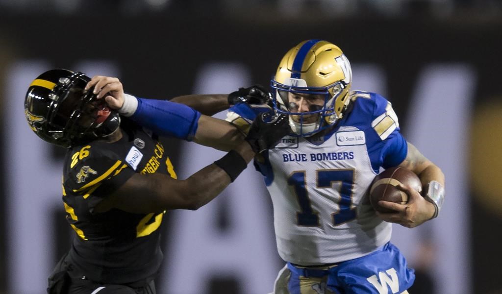 Winnipeg Blue Bombers quarterback Chris Streveler pushes away Hamilton Tiger-Cats’ Cariel Brooks during the second half of the 107th Grey Cup in Calgary on November 24, 2019.