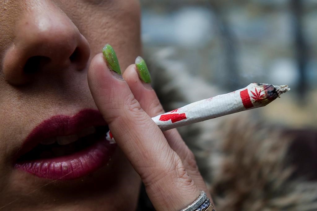 A woman smokes a marijuana joint.