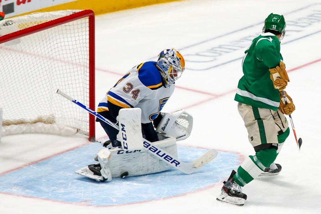 St. Louis Blues goaltender Jake Allen, left, makes a pad save on the shot by Dallas Stars center Andrew Cogliano, right, during the third period of an NHL hockey game in Dallas, Friday, Feb. 21, 2020.