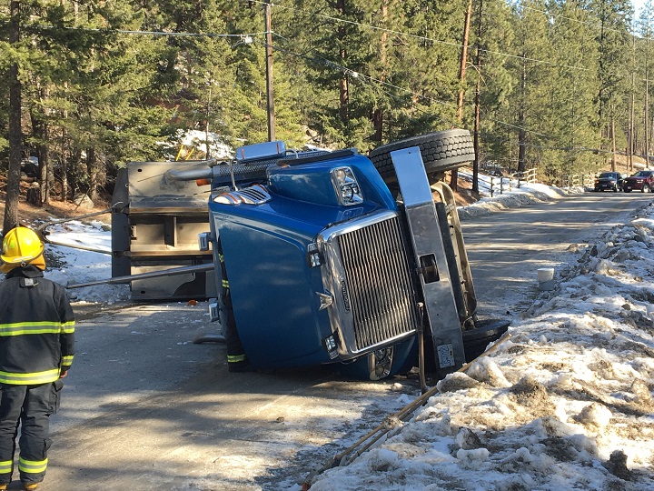 A dump truck on its side after its upright box caught overhead wires along Trepanier Road on Thursday.
