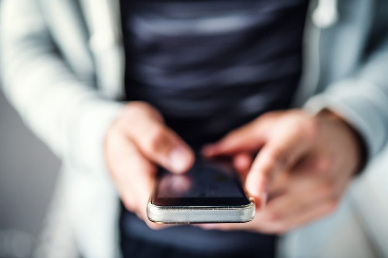 A person types on a smartphone in this stock image. 