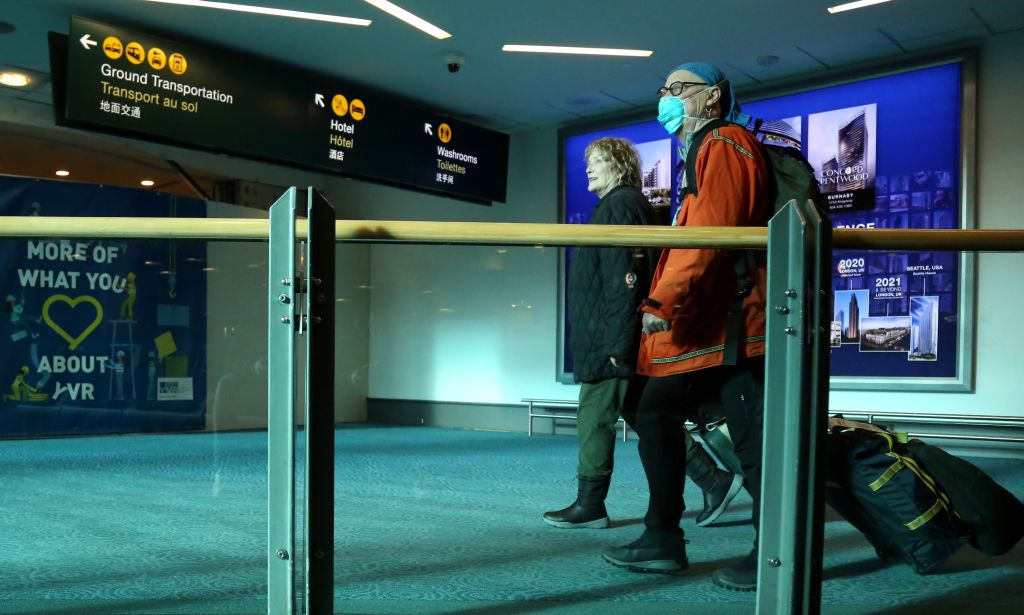 People wearing face masks are seen at Vancouver International Airport