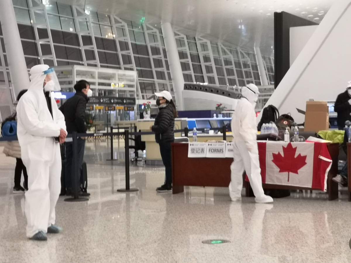 Officials wear protective gear in the Wuhan airport as medical screenings take place ahead of two evacuation flights on Feb. 6, 2020.