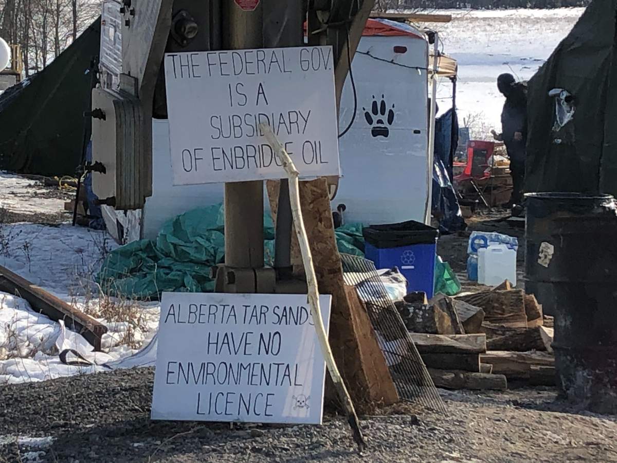 Signs sit by the rail line near Belleville, Ont., where a blockade protesting a pipeline in northern British Columbia has stopped rail traffic for seven days in a row.