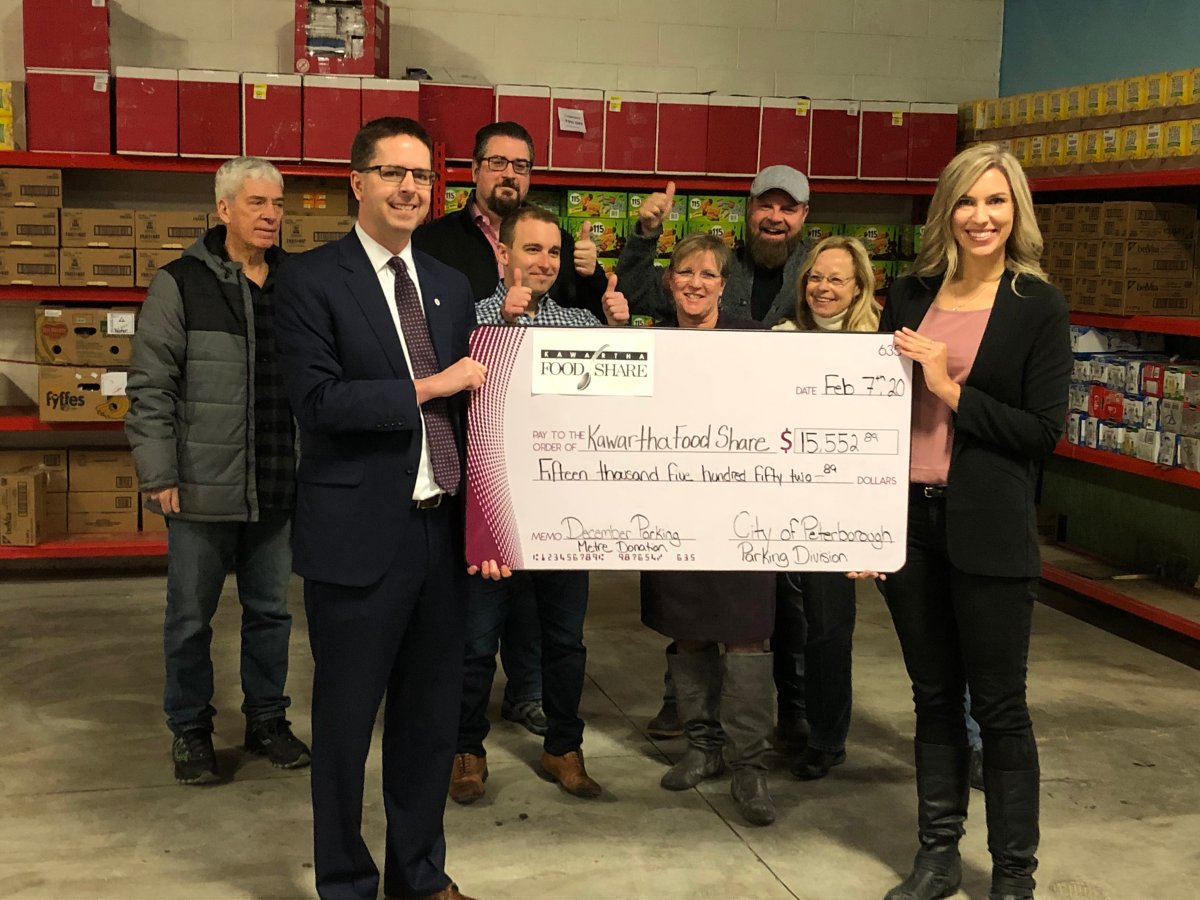 Peterborough Deputy Mayor Andrew Beamer presents a cheque to Ashlee Aitken of Kawartha Food Share from a parking fundraiser in December 2019.