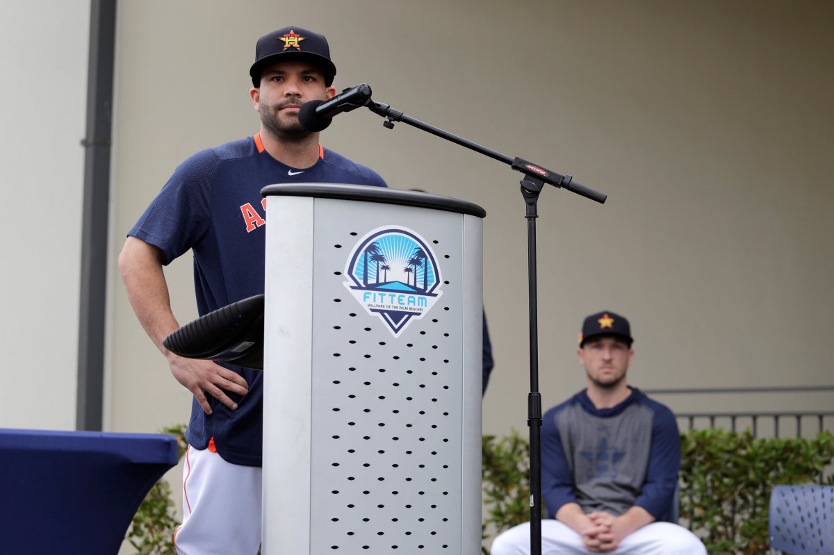 Houston Astros' Jose Altuve speaks at a podium as teammate Alex Bregman, seated right, looks on during a news conference before the start of the first official spring training baseball practice for the team Thursday, Feb. 13, 2020, in West Palm Beach, Fla.