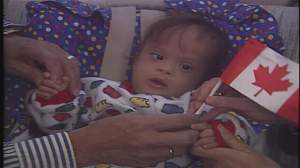 A photo of a baby Jose Moran Robles holding a Canadian flag.