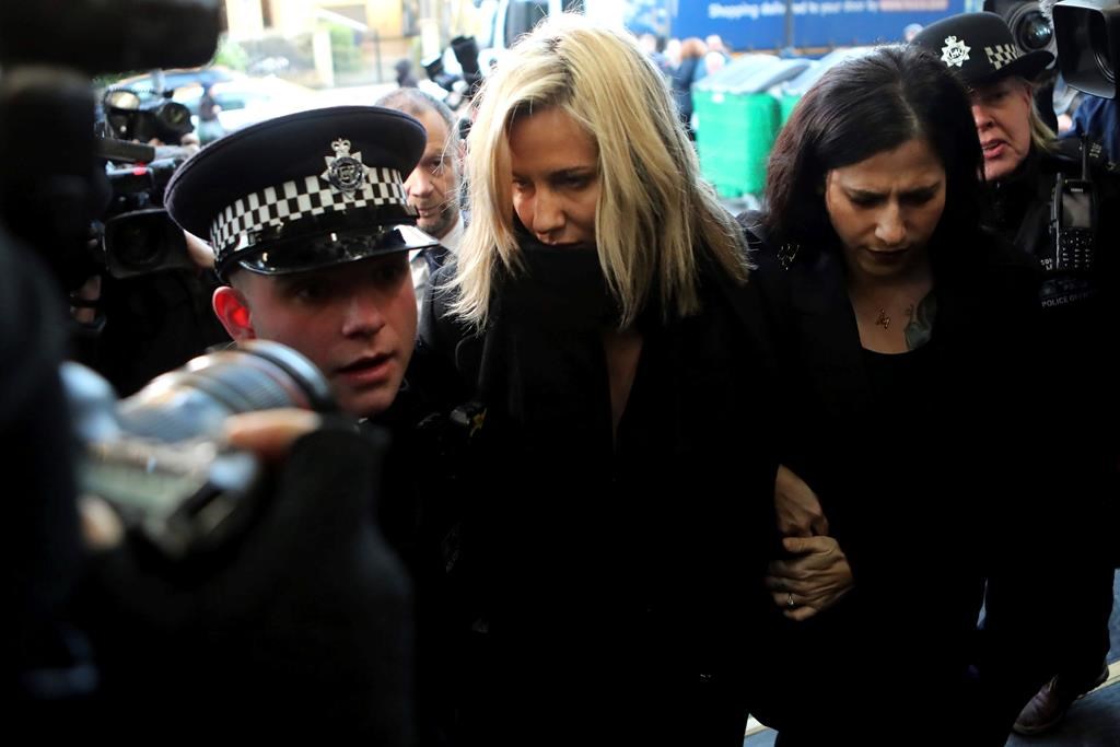 In this file photo dated Monday, Dec. 23, 2019, ‘Love Island’ TV presenter Caroline Flack, centre, is escorted by police as she arrives at court in London, England after being charged with assault of former professional tennis player and model Burton.