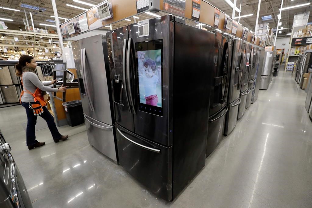 In this Jan. 27, 2020 photo a worker pushes a cart past refrigerators at a Home Depot store.