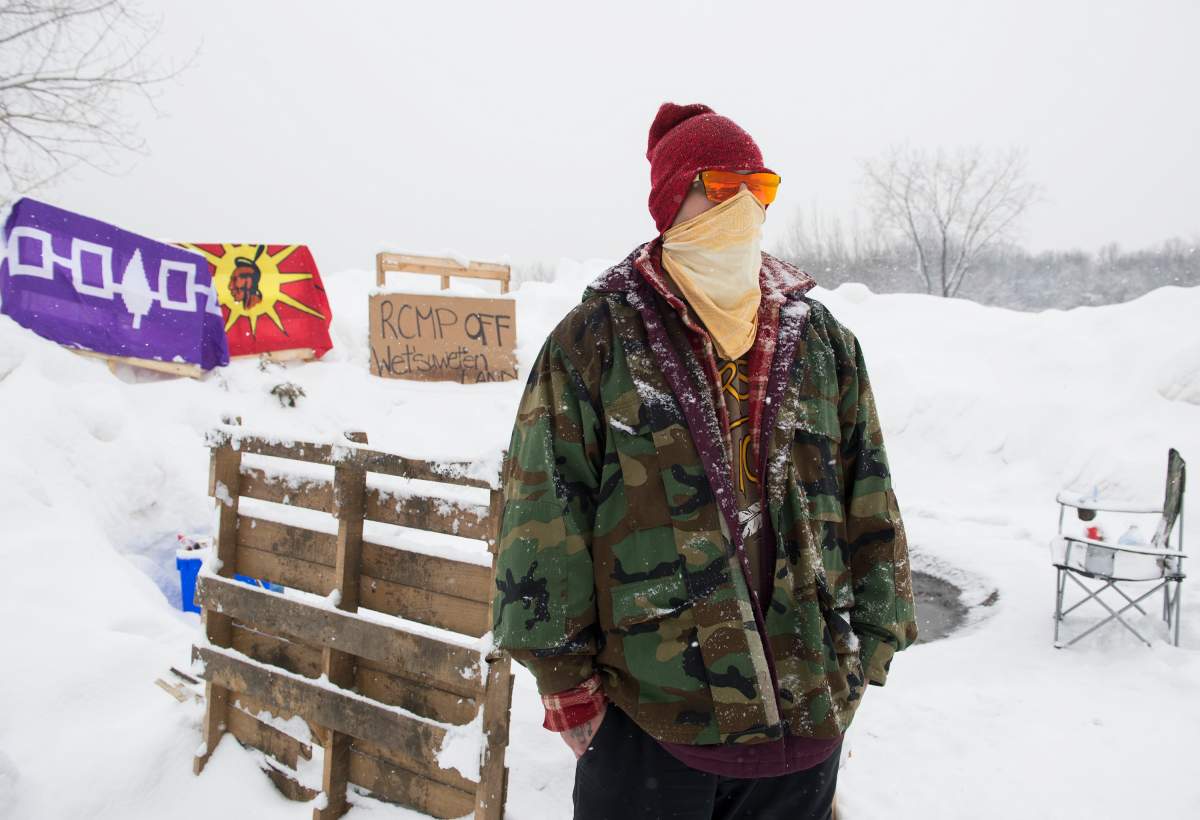 A member of the Mohawk community is seen on the Kahnawake reserve near a Canadian Pacific rail track south of Montreal, Monday, Feb. 10, 2020.
