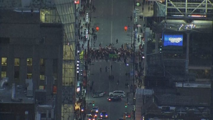 Protesters are seen blocking off the intersection of Yonge and Dundas streets in downtown Toronto Friday evening.