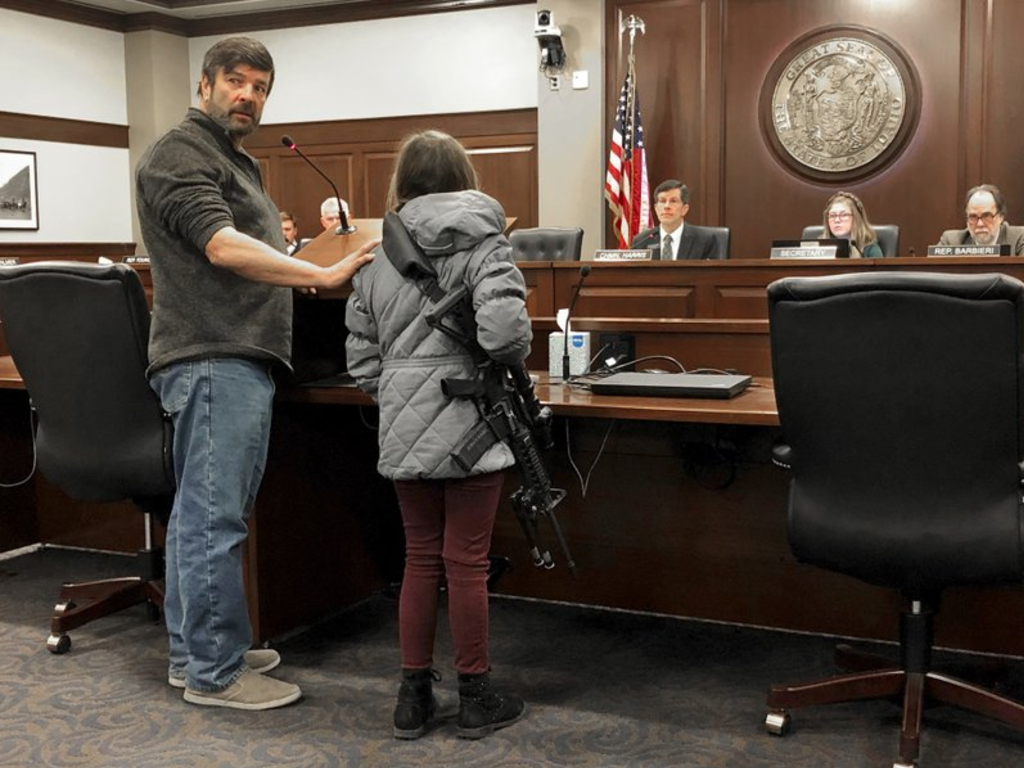 Charles Nielsen, 58, and his 11-year-old granddaughter, Bailey Nielsen, testify before a House panel at the Idaho Statehouse on Monday. Feb. 24, 2020 in Boise, Idaho. Visitors to Idaho 18 and older who can legally possess firearms would be allowed to carry a concealed handgun within city limits under legislation that headed to the House on Monday, Feb. 24.