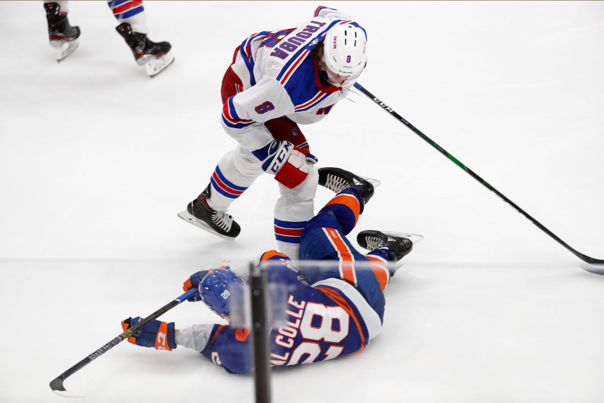 New York Rangers defenseman Jacob Trouba (8) leans over New York Islanders left wing Michael Dal Colle (28) after a legal hit Feb. 25, 2020, in Uniondale, N.Y. 