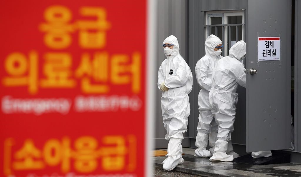 Officials wearing protective attire work to diagnose people with suspected symptoms of the new coronavirus at a hospital in Daegu, South Korea, Wednesday, Feb. 26, 2020.