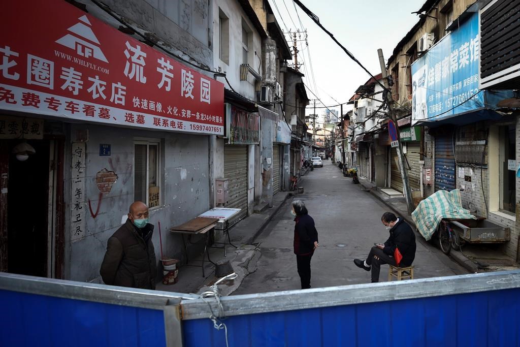 A volunteer keeps guard near the barricades to a residential area in Wuhan in central China's Hubei province.