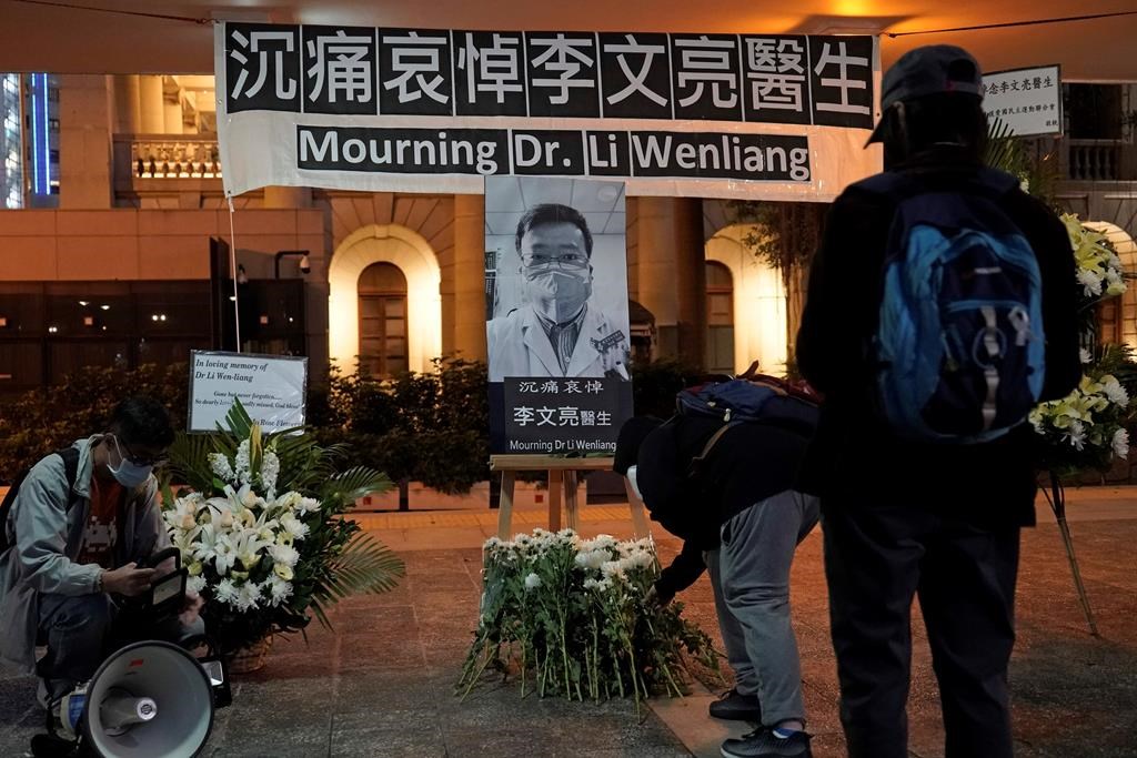 People attend a vigil for Chinese doctor Li Wenliang, in Hong Kong, Friday, Feb. 7, 2020. The death of a young doctor who was reprimanded for warning about China’s new virus triggered an outpouring of praise for him. (AP Photo/Kin Cheung)