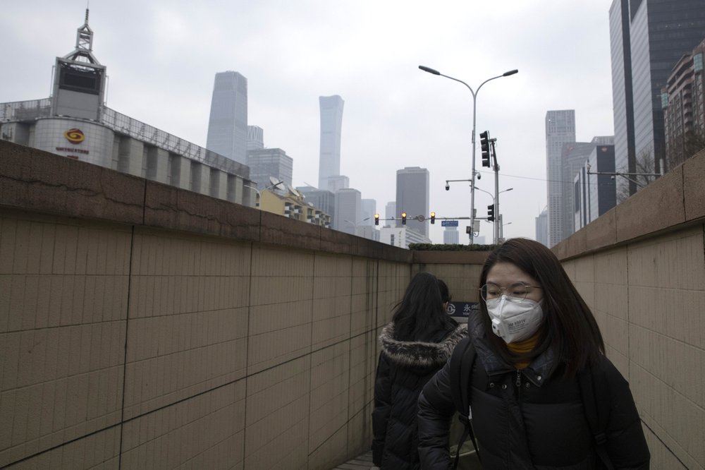 Residents walk out of a subway station near the central business district in Beijing Monday, March 9, 2020. With almost no new COVID-19 cases being reported in Beijing, workers are slowly returning to their offices with masks on and disinfectant in hand. But officials remain cautious, torn between wanting to restart the economy and fear of a resurgence of the outbreak. 