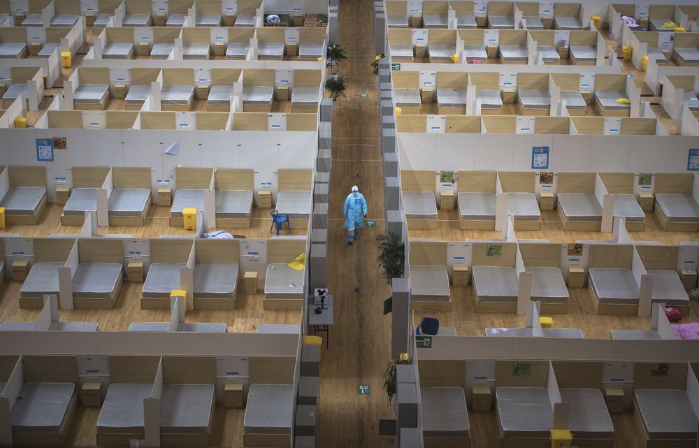 In this March 8, 2020, photo released by Xinhua News Agency, a staff member walks down a corridor of an empty makeshift hospital in Wuhan, central China's Hubei Province. The makeshift hospital converted from a sports venue was officially closed on Sunday after its last batch of cured COVID-19 patients were discharged. (Xiao Yijiu/Xinhua via AP)
.