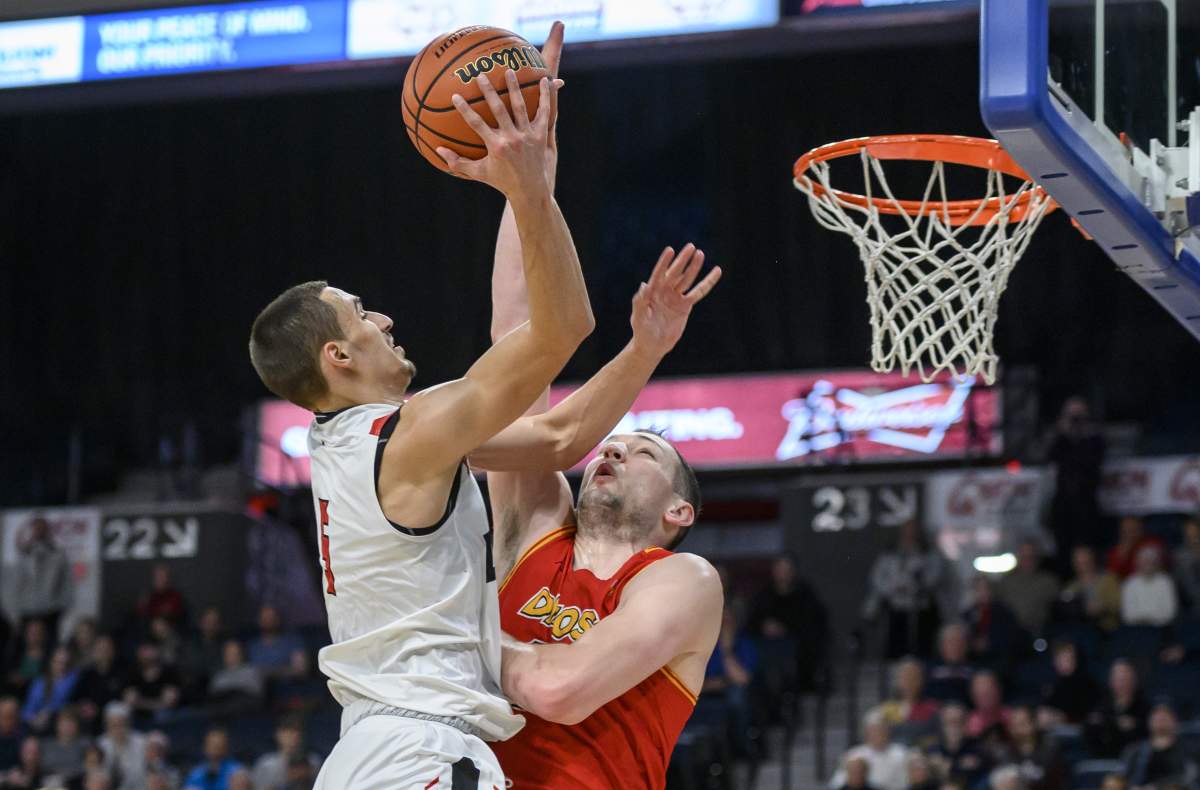 Carleton Ravens' Isiah Osborne, left, scores over University of Calgary Dinos' Brett Layton during the second half of the gold medal final in the USports men's basketball national championship in Halifax on Sunday, March 10, 2019.
