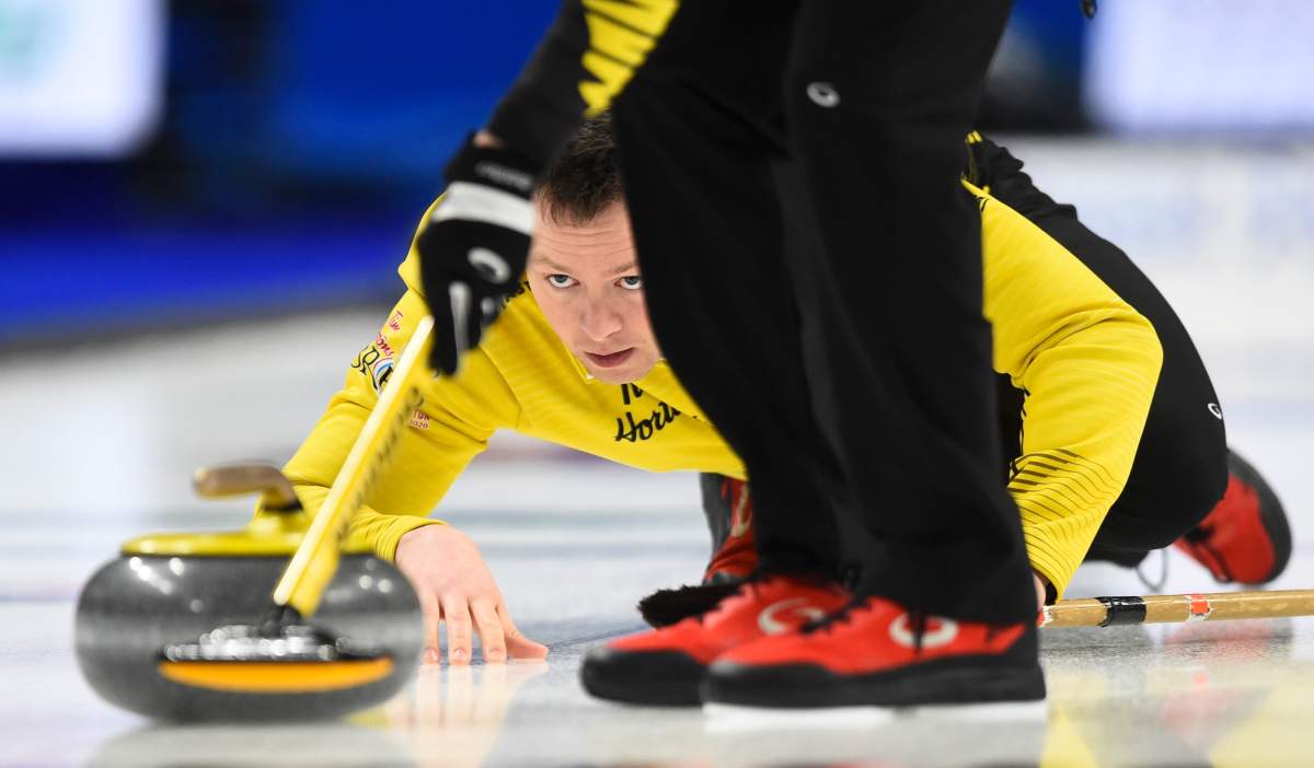 Team Manitoba skip Jason Gunnlaugson delivers a stone at the Brier in Kingston, Ont.